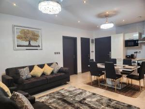 Una sala de estar con un sofá y una mesa con sillas. en Luxurious & Comfy Gem-5 Star Location-Pools Gym!, en Accra