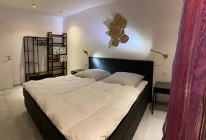 ein Schlafzimmer mit einem großen Bett mit weißer Bettwäsche in der Unterkunft Strandnah und ruhig mit Tiefgaragenstellplatz in Sierksdorf