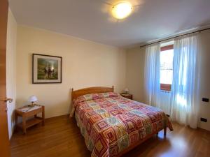 a bedroom with a bed and a window at Panoramic View Ledro Apartment in Mezzolago