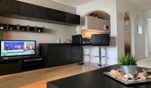 eine Küche mit einem Wohnzimmer mit einem TV und einem Tisch in der Unterkunft Laguna Beach, Todos los Santos in Torrox Costa