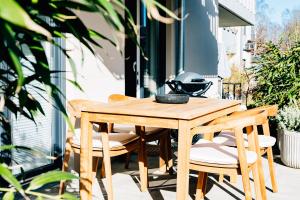 a wooden table and chairs on a patio at Ferienwohnung Nordic Calm am Kellersee in Malente
