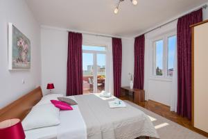 Un dormitorio con una gran cama blanca con almohadas rojas. en SeaView Apartment Ploce, en Dubrovnik