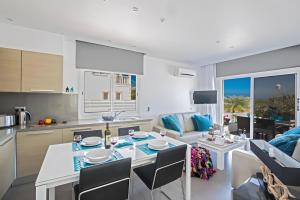 una cucina e un soggiorno con tavolo e sedie di Sun & Sea Seaview Apartment a Protaras