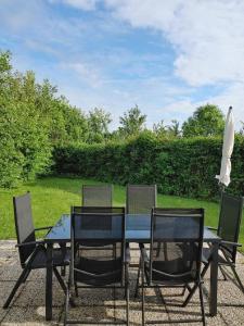 een tafel met drie stoelen en een paraplu bij Kustverhuur, Park Schoneveld, Zeester 68 in Breskens