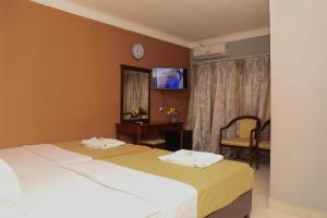 a hotel room with two beds and a tv at Mansea Beach Hotel in Kololi +30 photos