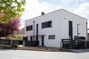 a white building with black shuttered windows at Apartment Bianca in Salzburg