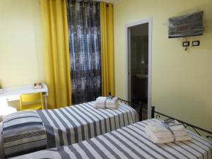two beds in a hotel room with towels on them at HOME SWEET HOME in Sammichele di Bari