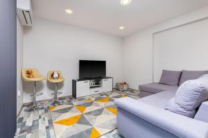 a living room with a couch and a tv at Florance flat next to Old Town & City Center NEW in Plovdiv