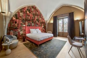 a bedroom with a bed and a wall with a mural at Les Suites de l'Ile Barbe in Lyon