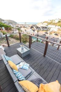 a balcony with a couch and a view of the ocean at Beach Lovers Paradise in Portreath - With Sea Views & Log Burner just 100m from beach in Portreath