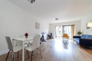 a living room with a table and a blue couch at Modern 3BDR Flat w large balcony, Kentish Town in London