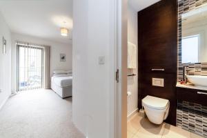 1 cama y baño con aseo y lavamanos. en Modern 3BDR Flat w large balcony, Kentish Town en Londres