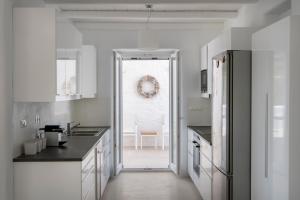 a kitchen with white cabinets and a door leading to a dining room at White Santa Maria Villa in Santa Maria