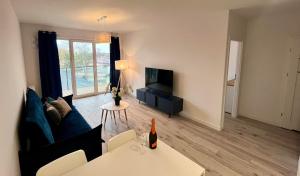 Una sala de estar con un sofá y un televisor. en Apartament z basenem i sauną, en Dziwnów