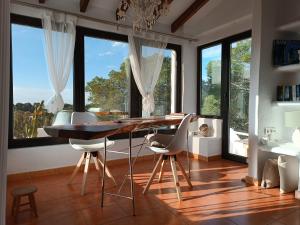 a dining room with a table and chairs and large windows at wonderful sunsets views from terraces Last minute in Cala Vadella
