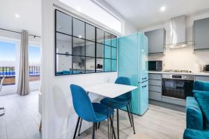 a kitchen with blue chairs and a table in a room at Luxury Heathrow 1 & 2 Bedroom Apts, West Drayton Free parking By 360Stays in West Drayton