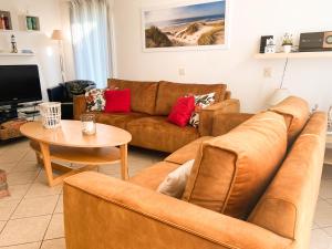 een woonkamer met een bank en een tafel bij Hello Zeeland - Vakantiehuis Zeester 66 in Breskens