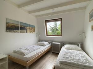 two beds in a room with a window at Hello Zeeland - Vakantiehuis Zeester 66 in Breskens