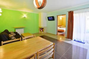 a living room with green walls and a wooden table at Comfortable holiday home with a private garden, close to the sea, Sarbinowo in Sarbinowo