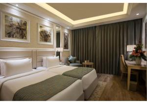 ein Hotelzimmer mit 2 Betten und einem Schreibtisch in der Unterkunft Singhania Sarovar Portico in Raipur