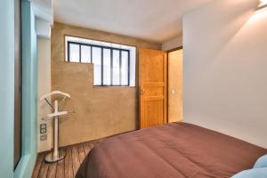 卡魯雷埃奎耶的住宿－Appartement Le Cosy - Calme & Chaleureux - Bien situé，一间卧室设有一张床和一个窗口