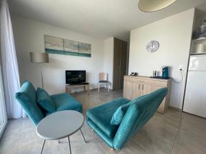 - un salon avec deux chaises vertes et une table dans l'établissement Mini villa K2, à Bonifacio