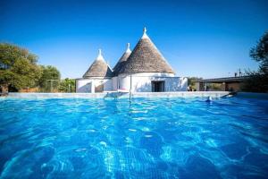 オストゥーニにあるTrullo Ostuni Terre di Santaの家の前の青い水のスイミングプール