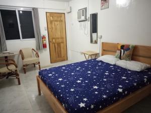 a bedroom with a bed with a blue blanket with stars at Kathleens Vacation Place in Moalboal