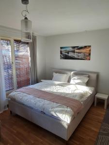 Una cama blanca en un dormitorio con ventana. en Spacious studio apartment in city center Tallinn, en Tallin