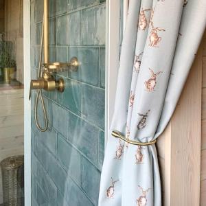 a shower curtain with a rabbit on it in a bathroom at Troney Valley Escapes - Hare's Hide in Crediton