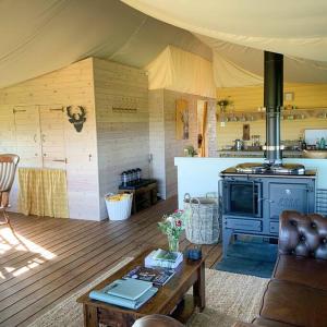 a living room with a stove in a tent at Troney Valley Escapes - Hare's Hide in Crediton