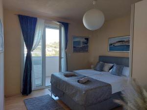 a bedroom with a bed and a large window at Apartman Stella Marina in Šibenik
