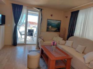 uma sala de estar com um sofá e uma mesa em Apartman Stella Marina em Sibenik