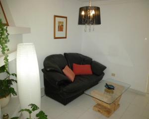 a black leather couch in a living room with a table at Apartment Frida in Los Cristianos