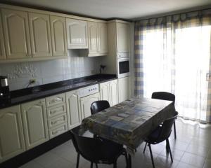 a kitchen with a table and chairs and a kitchen with white cabinets at Apartment Frida in Los Cristianos