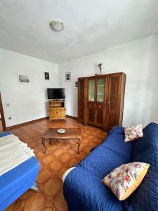 een woonkamer met een blauwe bank en een tafel bij Appartamento Albatros in Ribolla