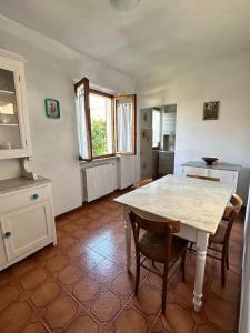 een keuken met een tafel en stoelen in een kamer bij Appartamento Albatros in Ribolla