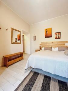 1 dormitorio con 1 cama grande y espejo en Villa Corocael, en Castellabate