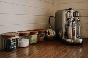 a kitchen counter with a blender and jars of food at Primrose Cottage in Mandurama