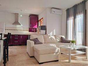 uma sala de estar com um sofá branco e uma mesa em Apartamentos Turísticos La Carrajolilla em Chiclana de la Frontera