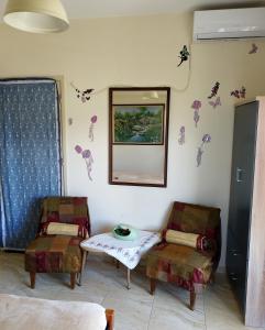 een kamer met 2 stoelen, een tafel en een spiegel bij Mom's Cozy Corner in Heraklion