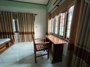 a room with a table and a chair and windows at Bountang Mountain View Riverside Hotel in Vang Vieng