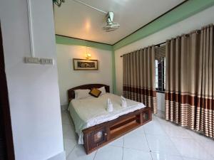 a bedroom with a bed and a window with curtains at Bountang Mountain View Riverside Hotel in Vang Vieng