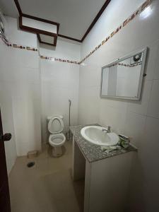 a white bathroom with a sink and a toilet at Bountang Mountain View Riverside Hotel in Vang Vieng