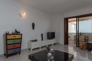 a living room with a tv and a table at Beach View in Los Cristianos