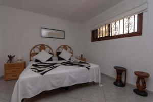a bedroom with a bed with white sheets and a window at Beach View in Los Cristianos