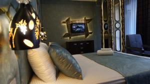 a bedroom with a bed with pillows and a mirror at Egoist luxury Hotel in Baku
