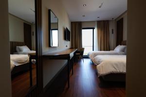 Pokój hotelowy z 2 łóżkami, biurkiem i lustrem w obiekcie Valza Boutique Hotel we Wlorze