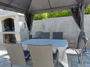 a table and chairs under an umbrella on a patio at Apartman Stella Marina in Šibenik