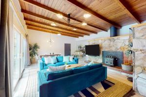 sala de estar con sofá azul y chimenea en Riverfront Escape, en Monte Rio